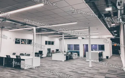 Empty Open Plan Office Workstations Under Linear Lights