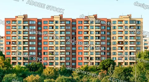 Exterior Of A Tall Brick Apartment Building Behind Lush Green Foliage