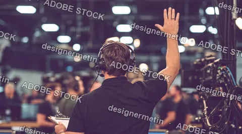 Rear View Of Television Studio Director Wearing Headset And Raising Hand