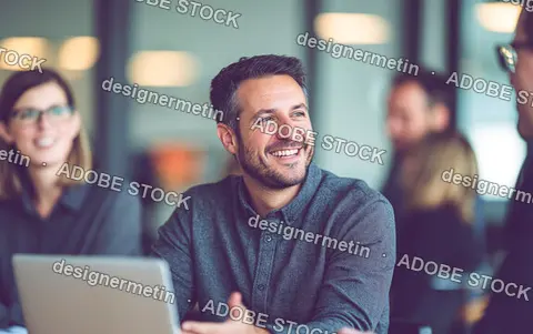 Smiling Businessman Participating In A Team Meeting Within A Modern Corporate Office