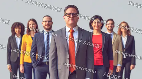 Confident Business Man In Suit And Orange Tie Standing With Team Behind Him