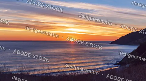 Sunset Over Calm Ocean With Distant Horizon, Glowing Clouds And Dark Coastal Cliffs